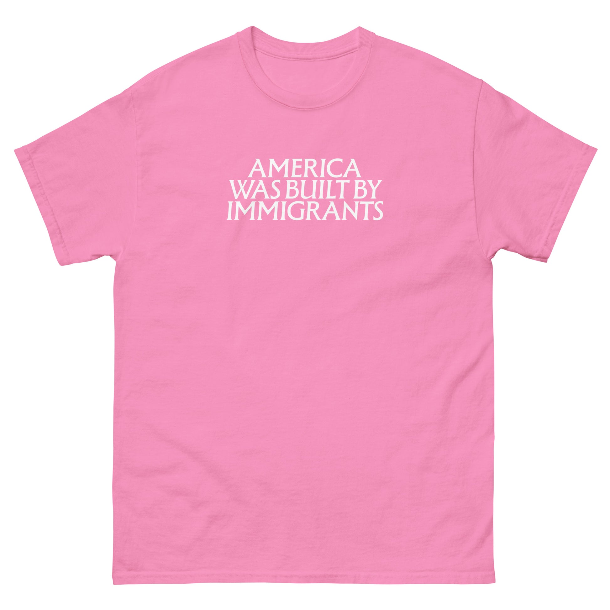 Pink unisex embroidered t-shirt with small white chest text in a clean serif font, minimalist pro-immigrant message stitched on soft fabric.