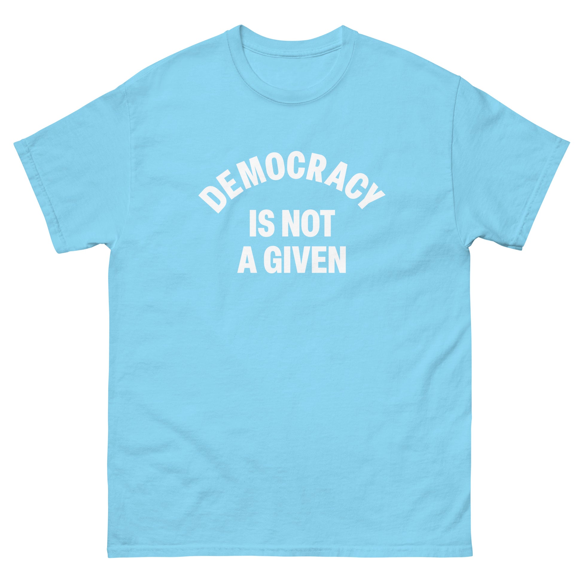 Light blue unisex t-shirt featuring curved “DEMOCRACY IS NOT A GIVEN” slogan in minimalist white font.