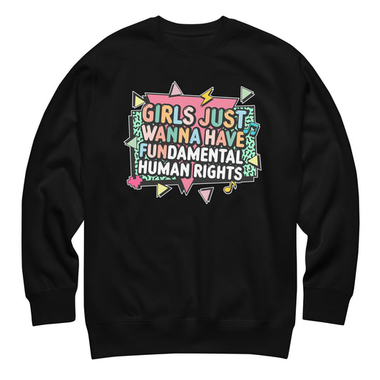 Black crewneck sweatshirt with colorful retro text reading “Girls Just Wanna Have Fundamental Human Rights.” 80s-inspired feminist design with pastel lightning bolts and triangles.