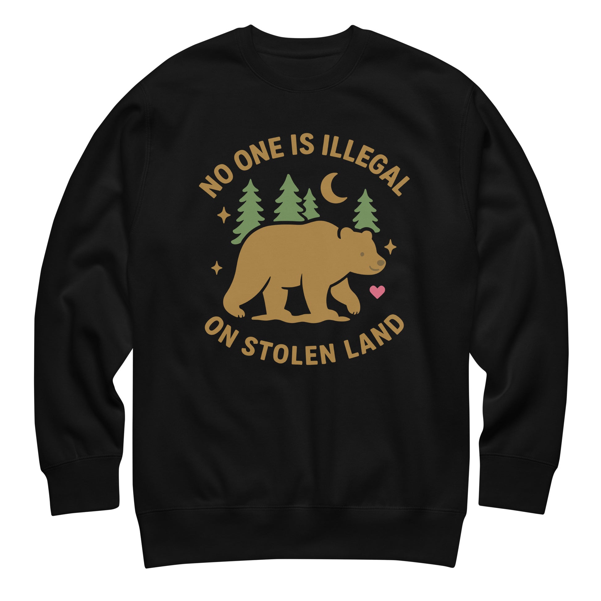 Black unisex premium sweatshirt featuring a tan bear, pine trees, moon, stars, and a small heart beneath the message “NO ONE IS ILLEGAL ON STOLEN LAND,” printed in warm earthy tones.
