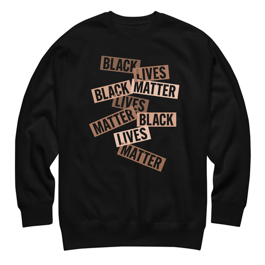 Black sweatshirt featuring layered cut-paper–style word strips reading “BLACK LIVES MATTER” arranged in a scattered layout. A bold civil-rights design supporting racial justice.