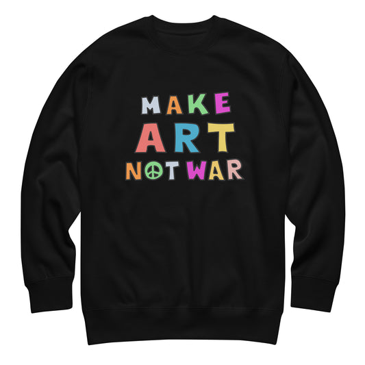 Black unisex premium sweatshirt featuring colorful block lettering arranged in a stacked layout reading “MAKE ART NOT WAR,” bold anti-war graphic centered on a solid black garment.