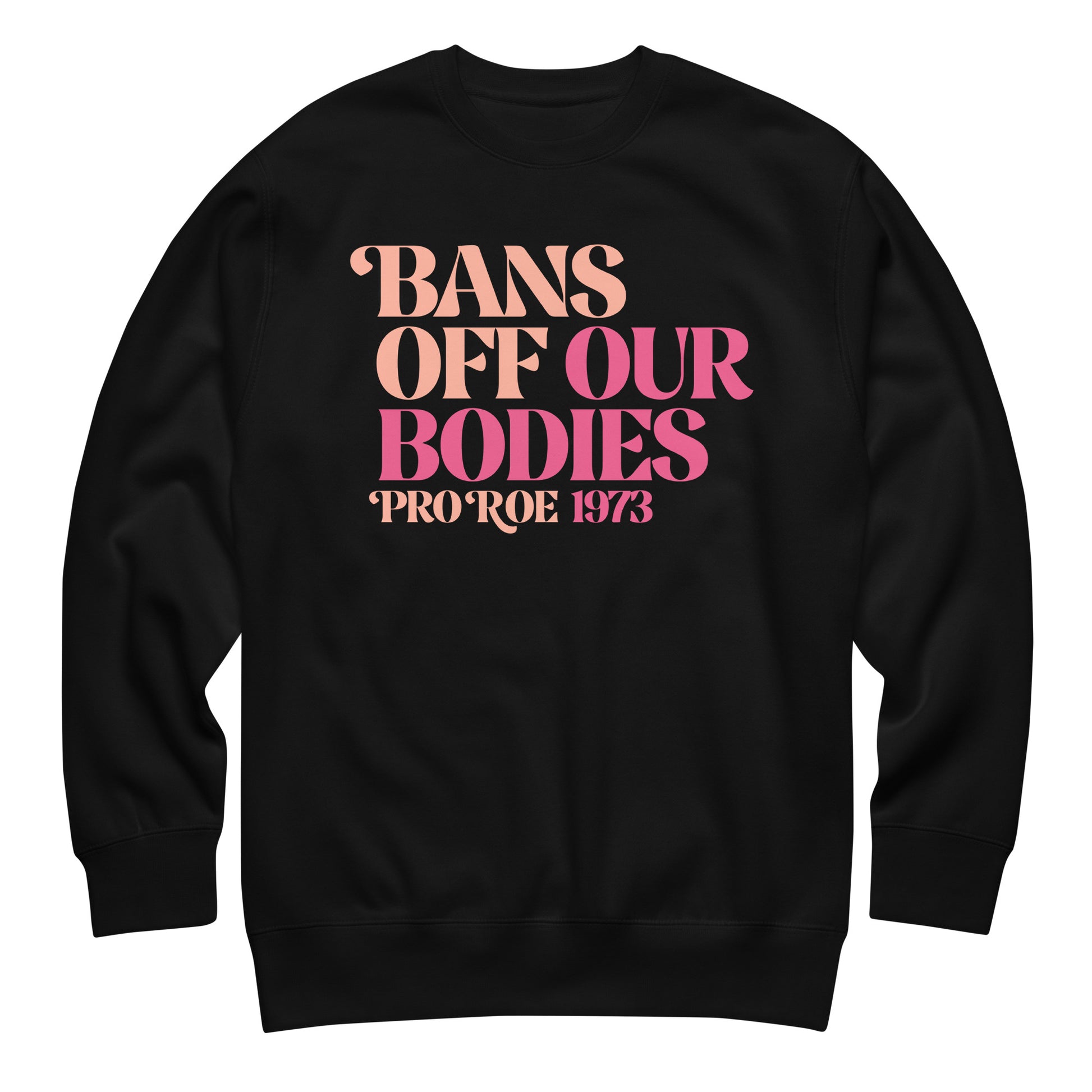 Unisex premium sweatshirt featuring retro serif typography in pink and peach gradient tones, bold stacked layout, printed message “BANS OFF OUR BODIES PRO ROE 1973,” black sweatshirt color.