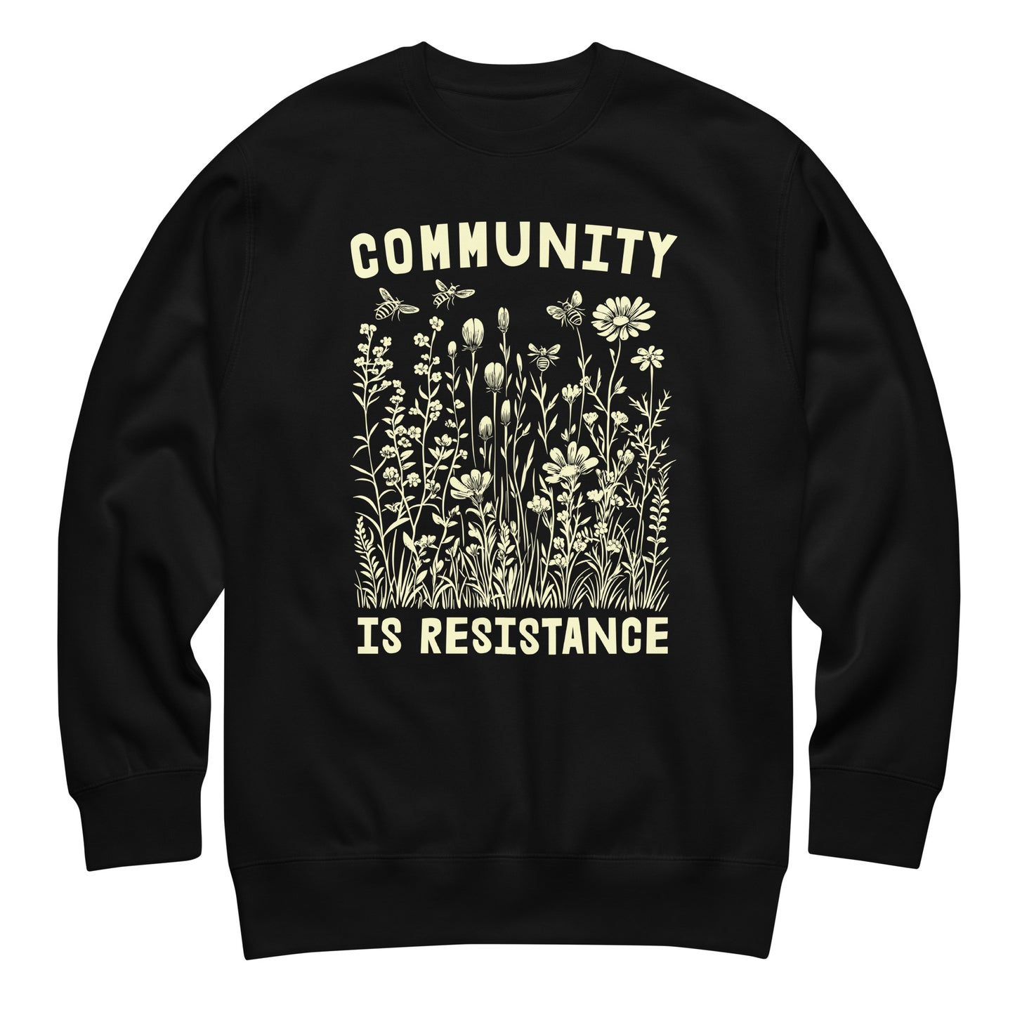 Black unisex premium sweatshirt featuring wildflower illustration with phrase “COMMUNITY IS RESISTANCE,” vintage botanical graphic, centered progressive activist apparel.