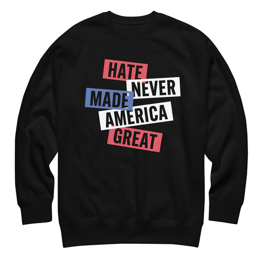 Black unisex premium sweatshirt featuring stacked block typography reading “HATE NEVER MADE AMERICA GREAT,” red, white, and blue patriotic graphic.
