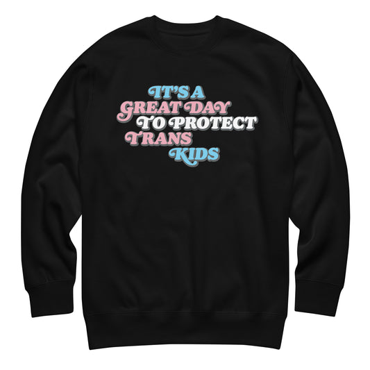Black unisex premium sweatshirt featuring retro stacked typography reading “It’s A Great Day To Protect Trans Kids,” progressive apparel from Blue Wave USA.