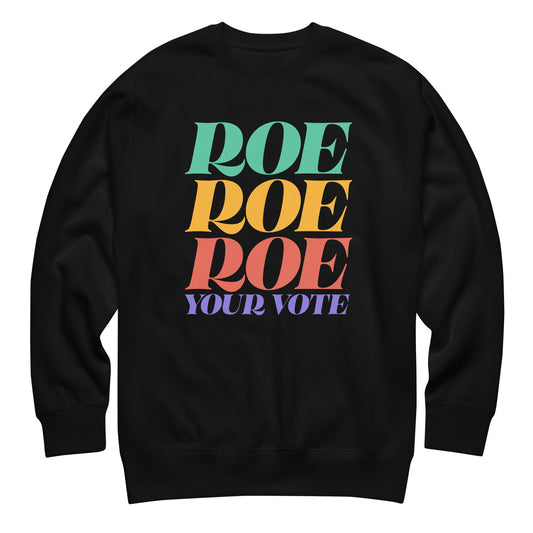 Black unisex premium sweatshirt featuring stacked rainbow typography reading “Roe Roe Roe Your Vote,” reproductive rights activist apparel from Blue Wave USA.