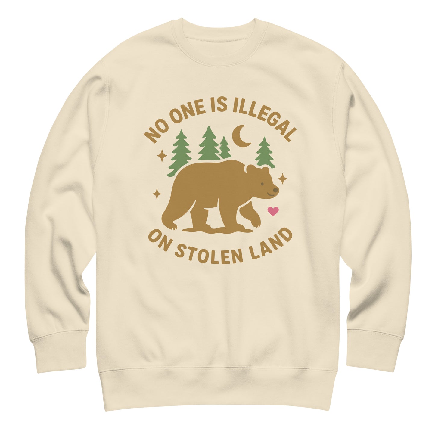 Sand unisex premium sweatshirt showing the bear, pine trees, moon, and heart illustration paired with the message “NO ONE IS ILLEGAL ON STOLEN LAND,” printed in earthy natural tones.