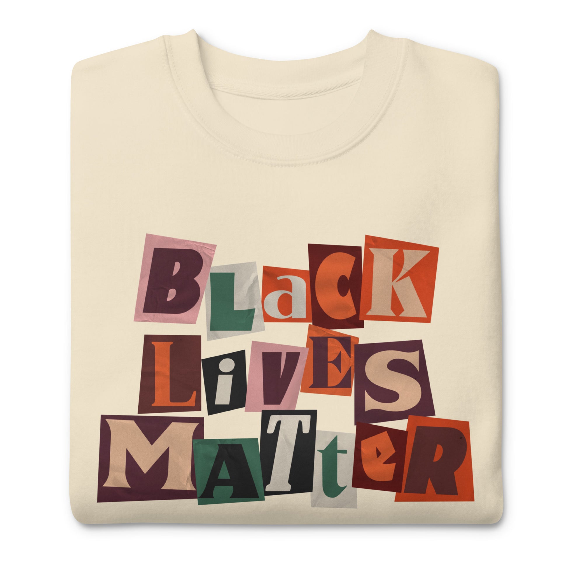 Cream unisex sweatshirt with multicolor collage lettering reading “BLACK LIVES MATTER” and the phrase “JUSTICE. EQUALITY. NOW.” in clean, centered type for a bold civil-rights message.