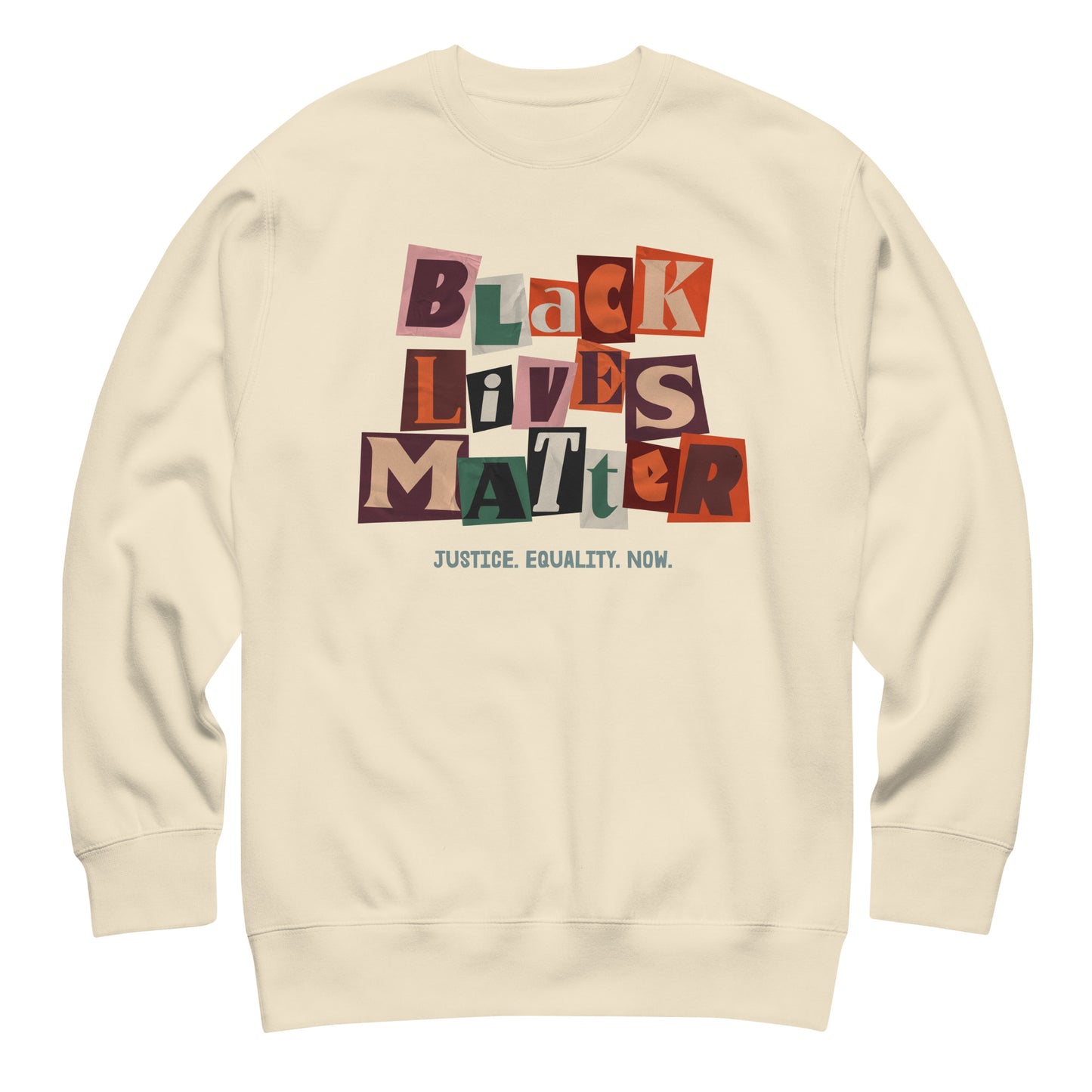 Cream sweatshirt printed with multicolored collage letters spelling “BLACK LIVES MATTER” and the line “JUSTICE. EQUALITY. NOW.” The soft palette contrasts with the strong activist layout.