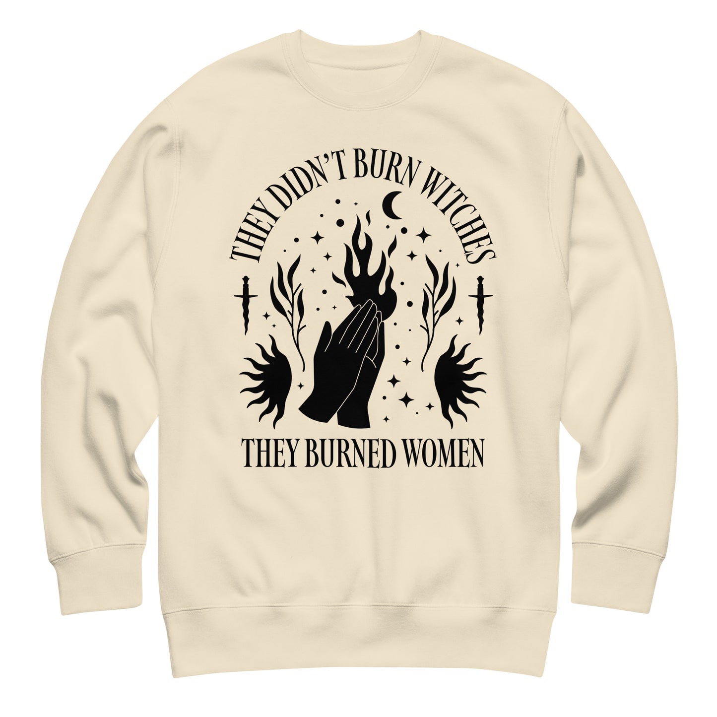 Cream unisex premium sweatshirt laid flat showing symmetrical flame and hand illustration with celestial accents, high-contrast print, printed message “THEY DIDN’T BURN WITCHES THEY BURNED WOMEN,” progressive apparel from Blue Wave USA.