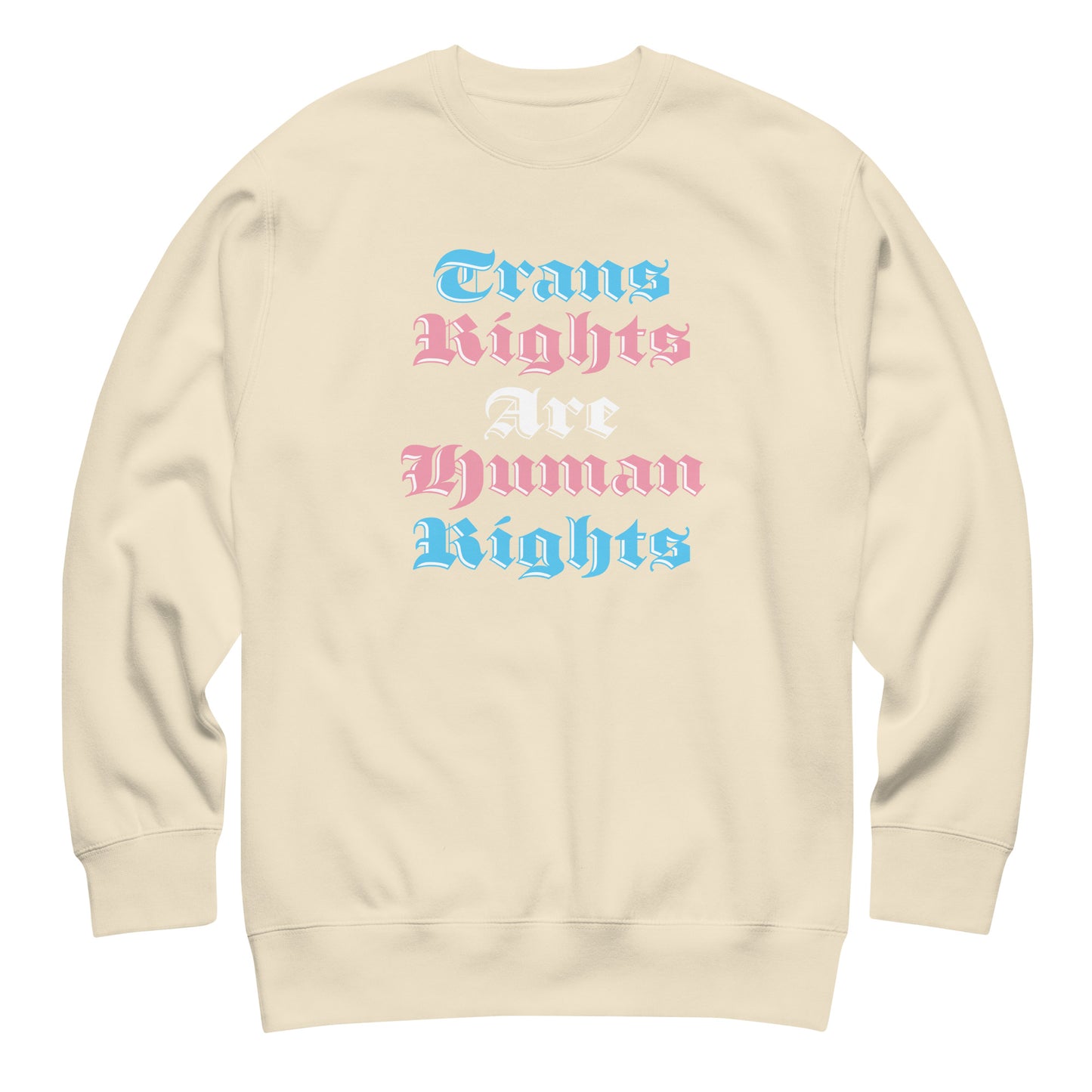 Sand-colored unisex premium sweatshirt featuring gothic stacked typography reading “Trans Rights Are Human Rights” in trans pride color palette.
