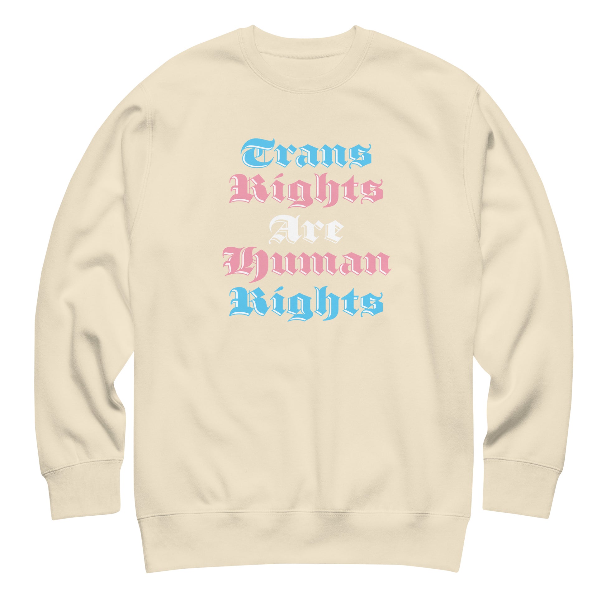 Sand-colored unisex premium sweatshirt featuring gothic stacked typography reading “Trans Rights Are Human Rights” in trans pride color palette.