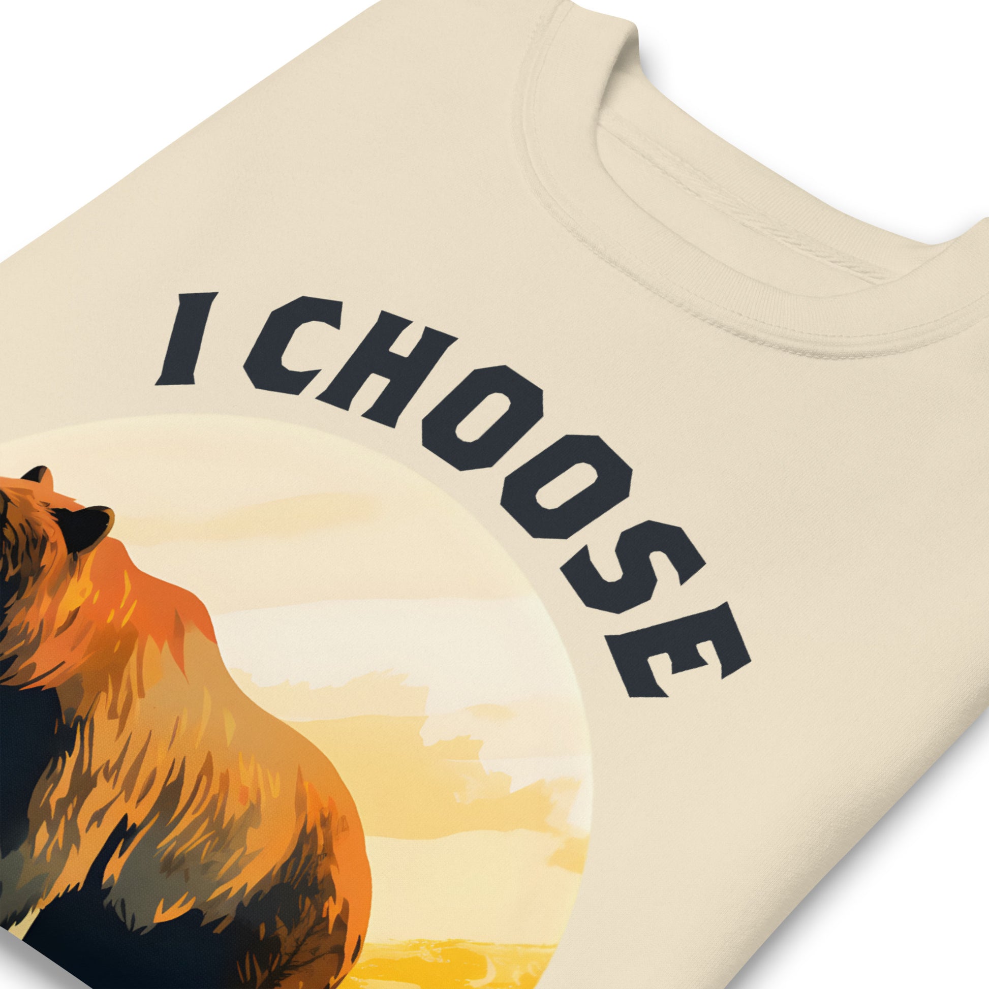 Sand unisex premium sweatshirt close-up featuring bear silhouette within sunset circle and phrase “I Choose The Bear,” feminist activist sweatshirt.