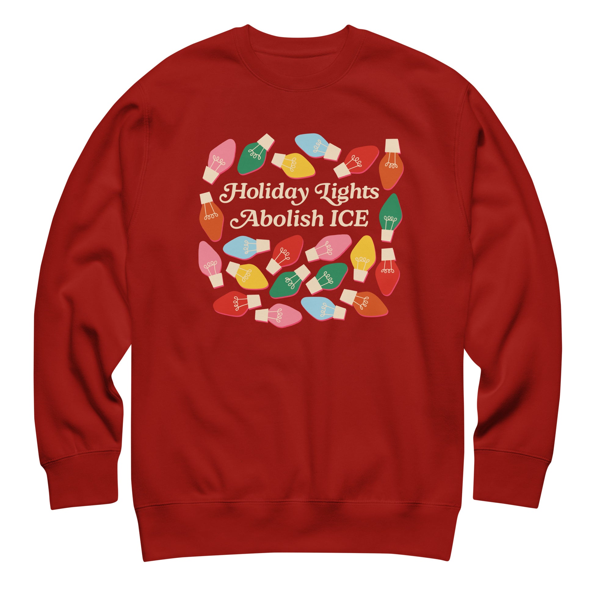 A red unisex sweatshirt featuring playful holiday bulbs surrounding “Holiday Lights Abolish ICE,” styled in a simple flat lay to emphasize its warm seasonal advocacy theme.