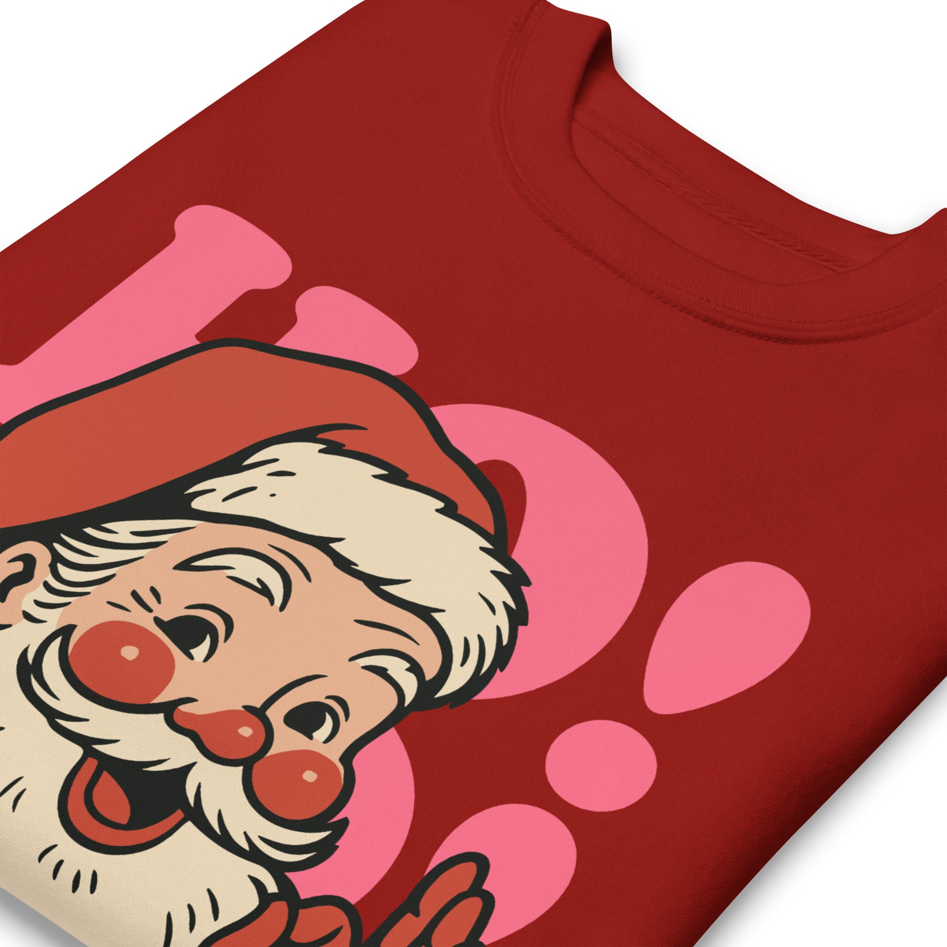 Close-up of a retro Santa illustration and pink “HO!” lettering with the printed phrase “Peace and Justice for All” on a red sweatshirt.