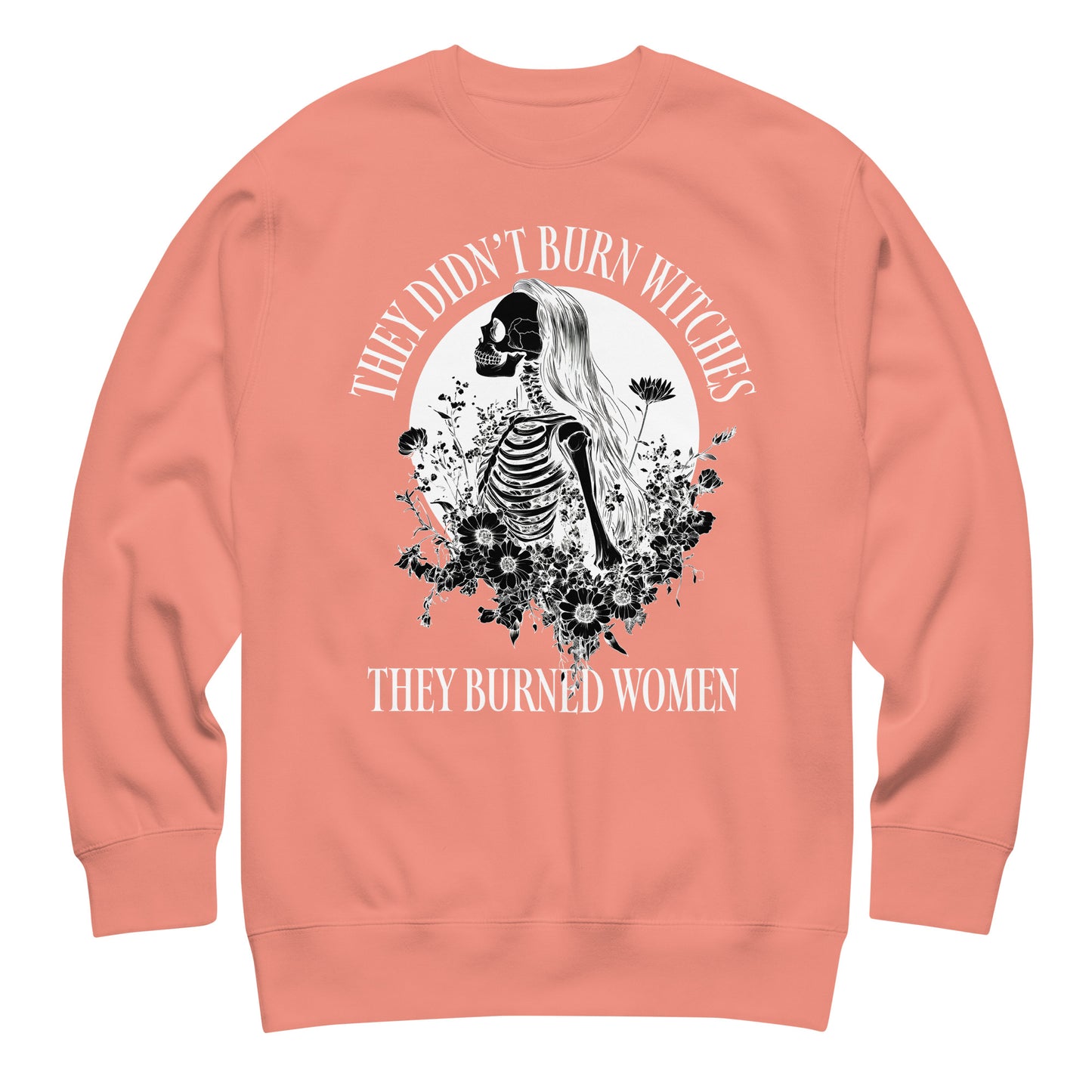 Peach unisex premium sweatshirt featuring detailed skeleton illustration framed by celestial motifs, centered graphic composition, printed message “THEY DIDN’T BURN WITCHES THEY BURNED WOMEN,” by Blue Wave USA.