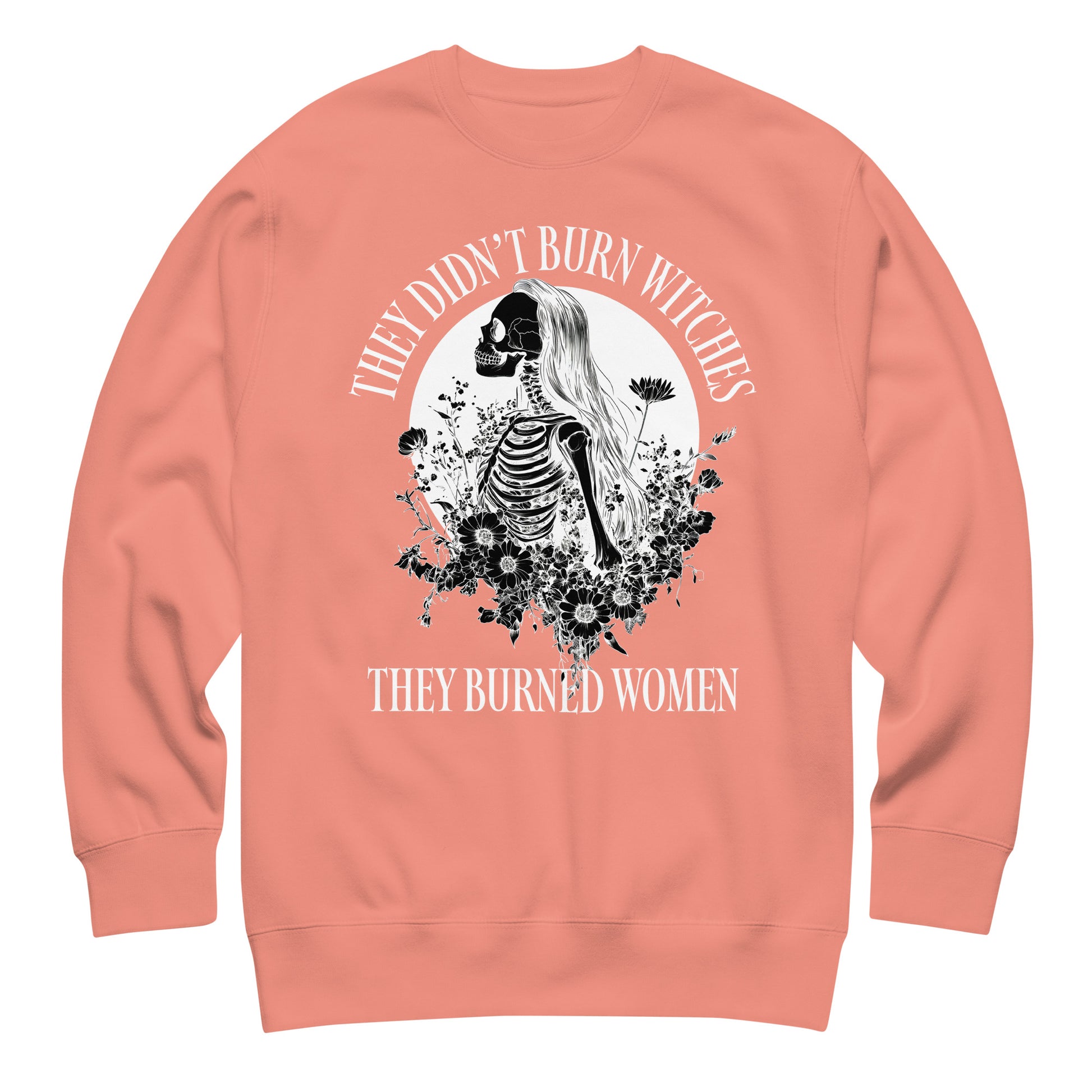Peach unisex premium sweatshirt featuring detailed skeleton illustration framed by celestial motifs, centered graphic composition, printed message “THEY DIDN’T BURN WITCHES THEY BURNED WOMEN,” by Blue Wave USA.