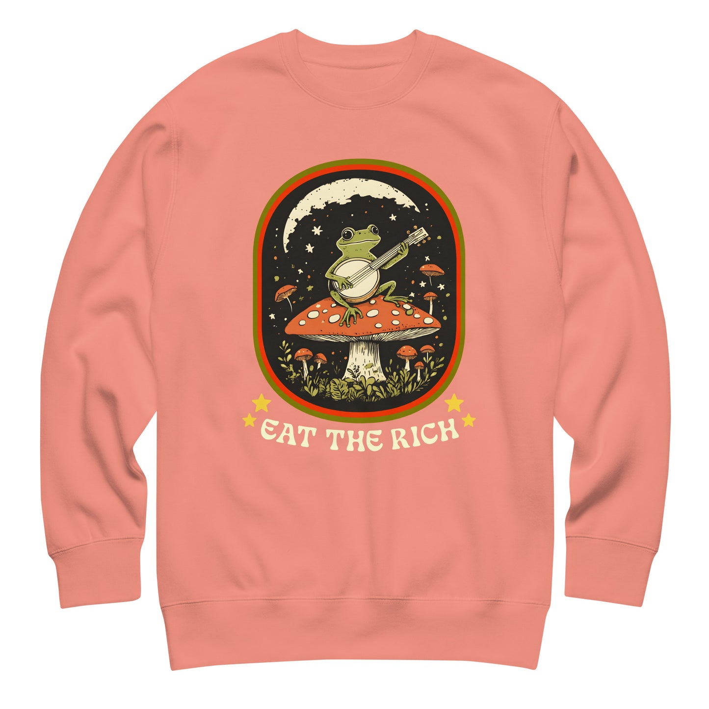 Coral unisex premium sweatshirt featuring illustrated frog banjo scene with bold “Eat The Rich” protest message.