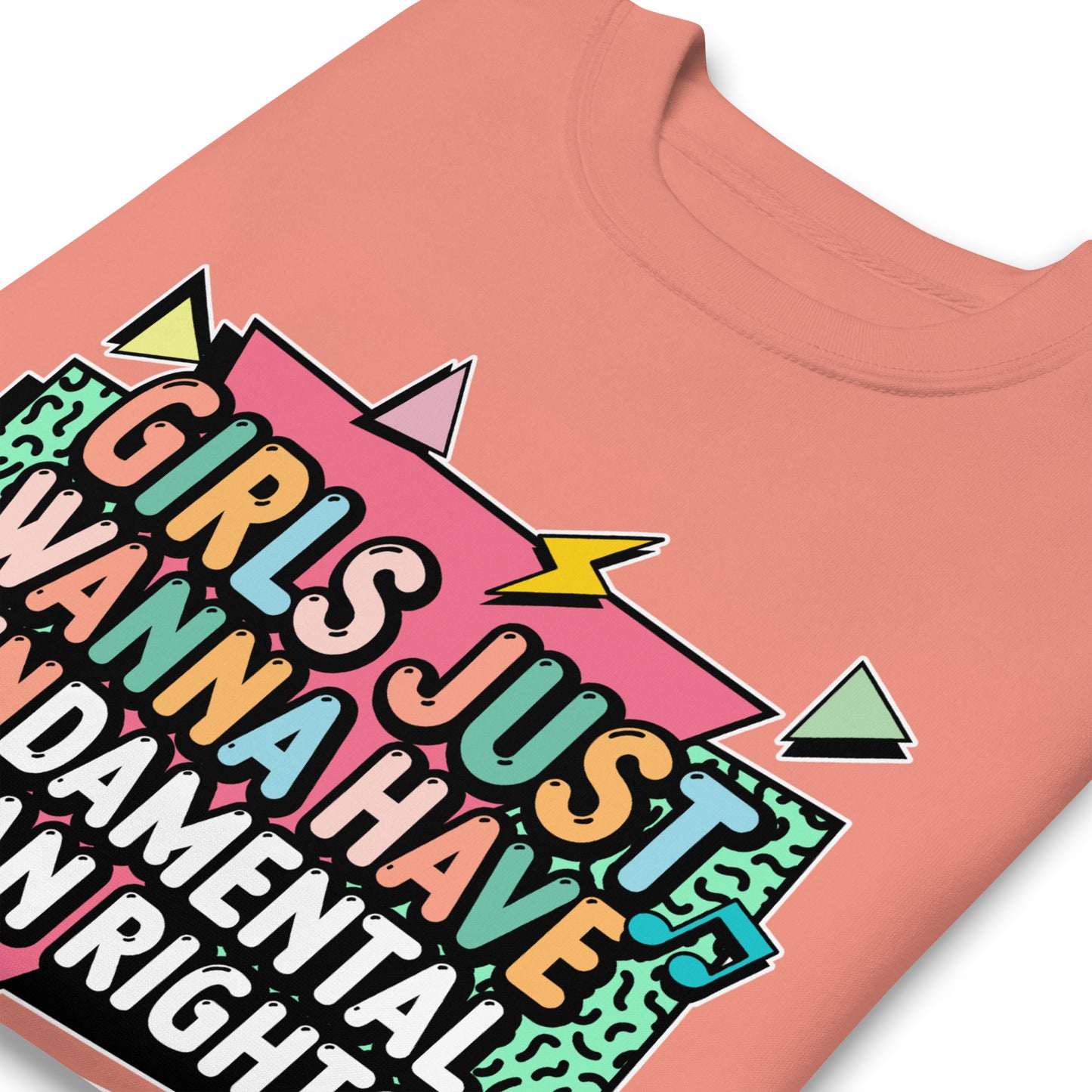 Close-up of the rose pink sweatshirt showing the vibrant geometric artwork and bold retro lettering. Cozy activism apparel celebrating women’s rights.