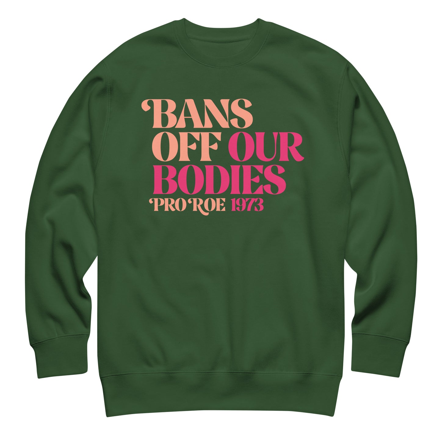 Forest green unisex premium sweatshirt laid flat featuring retro serif lettering in warm pink gradient, centered layout, printed message “BANS OFF OUR BODIES PRO ROE 1973.”
