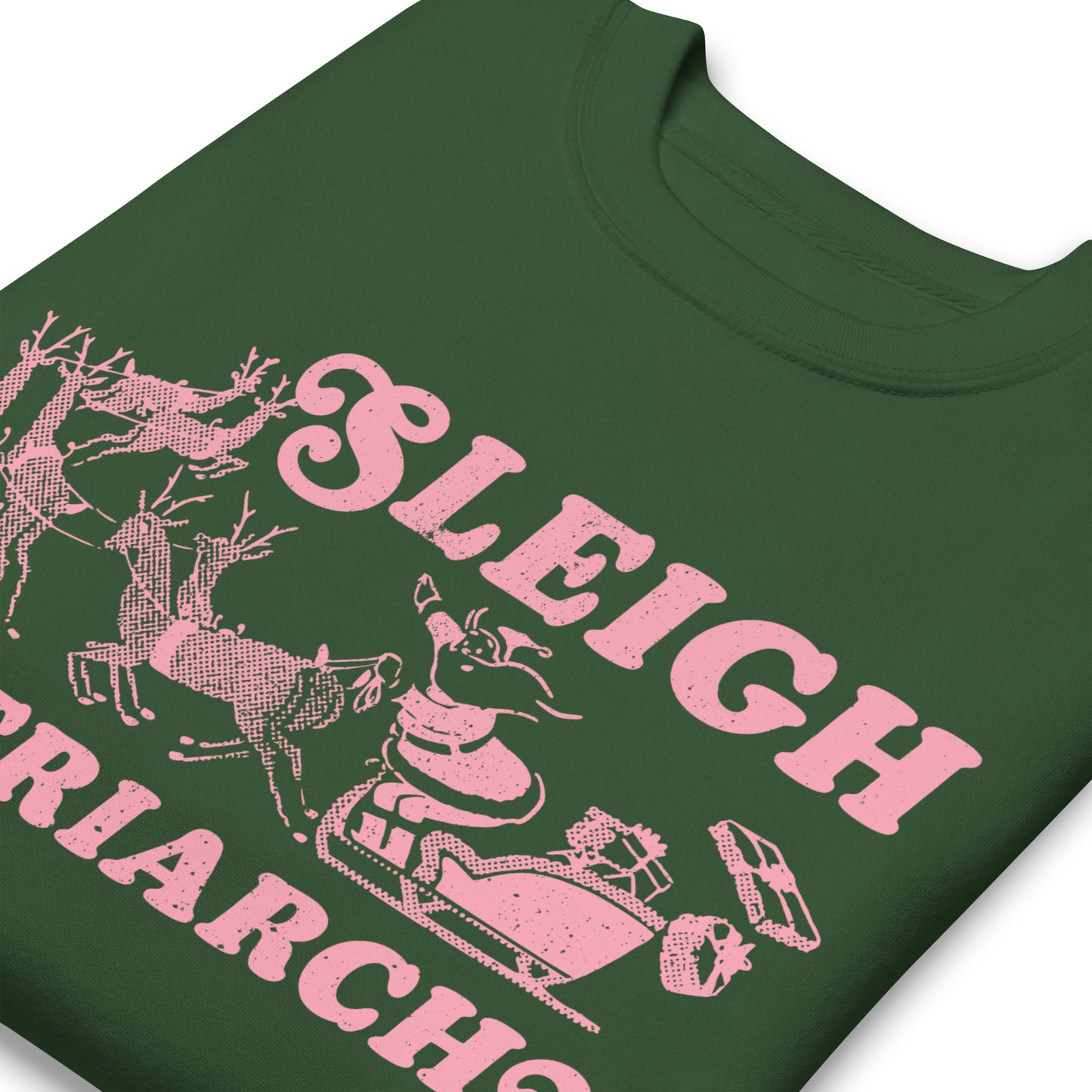 Close-up of the pink “Sleigh the Patriarchy” illustration printed on a green sweatshirt, highlighting Santa, reindeer, and the bold typography.