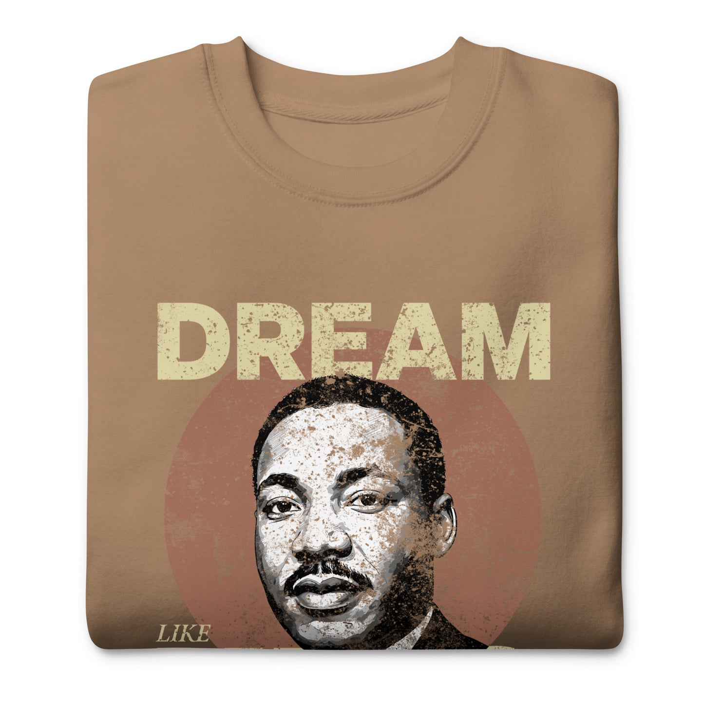 Tan unisex premium sweatshirt with a distressed “DREAM LIKE KING” message and MLK portrait inside a weathered circle. Vintage civil-rights theme.
