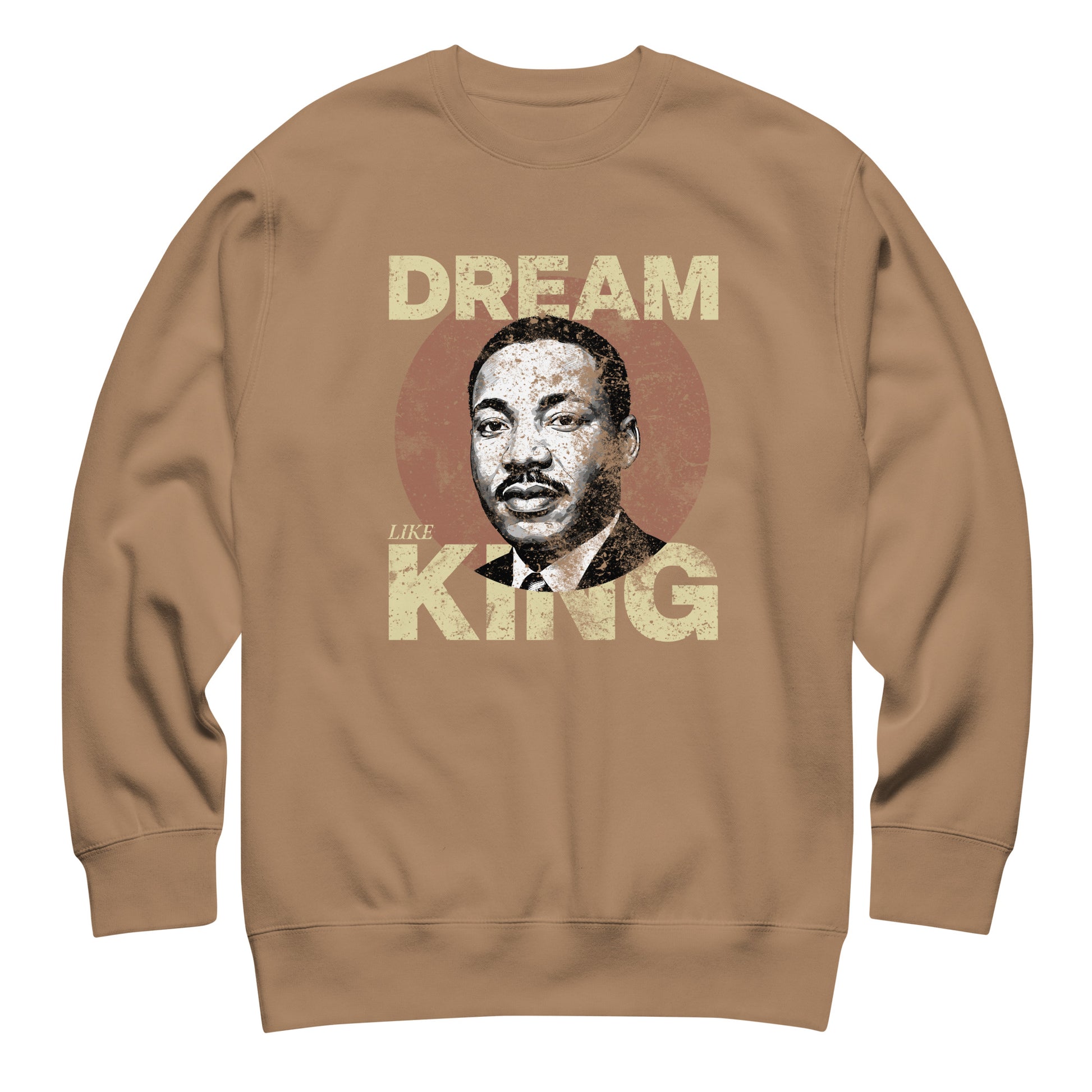 Tan unisex premium sweatshirt featuring distressed “DREAM LIKE KING” text with MLK’s portrait inside a weathered circle. Vintage activist look.