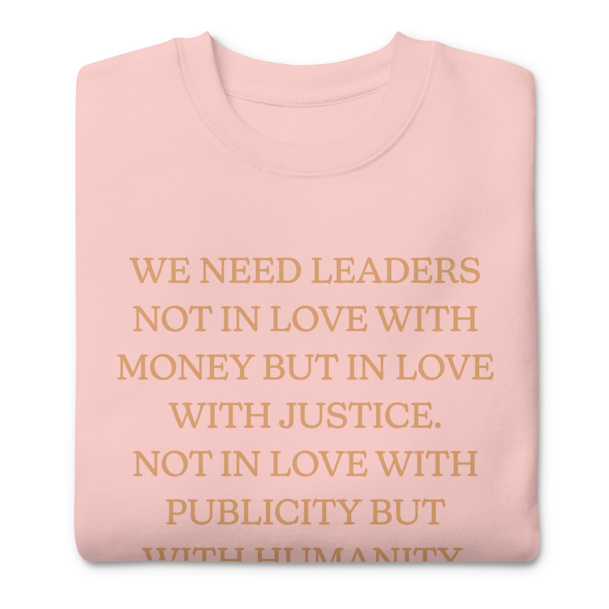 Light pink unisex premium sweatshirt displaying the full MLK quote calling for leaders who choose justice over money and humanity over publicity. Soft, minimalist activist style.