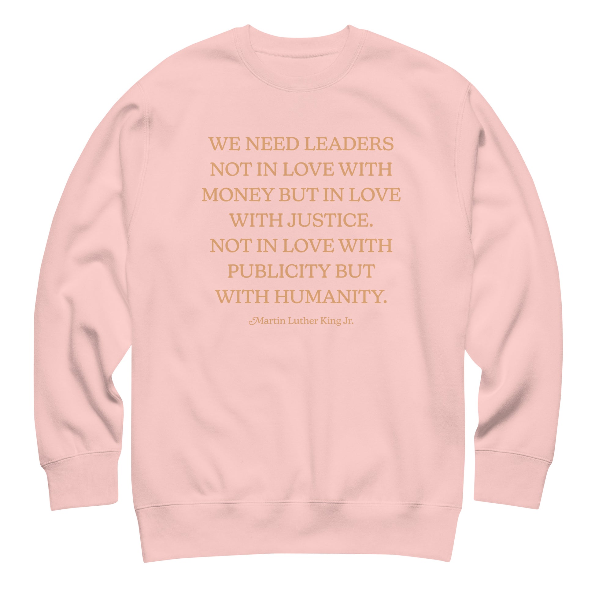 Light pink unisex premium sweatshirt showing the centered MLK quote on the back, highlighting a justice-centered message in warm, understated typography.