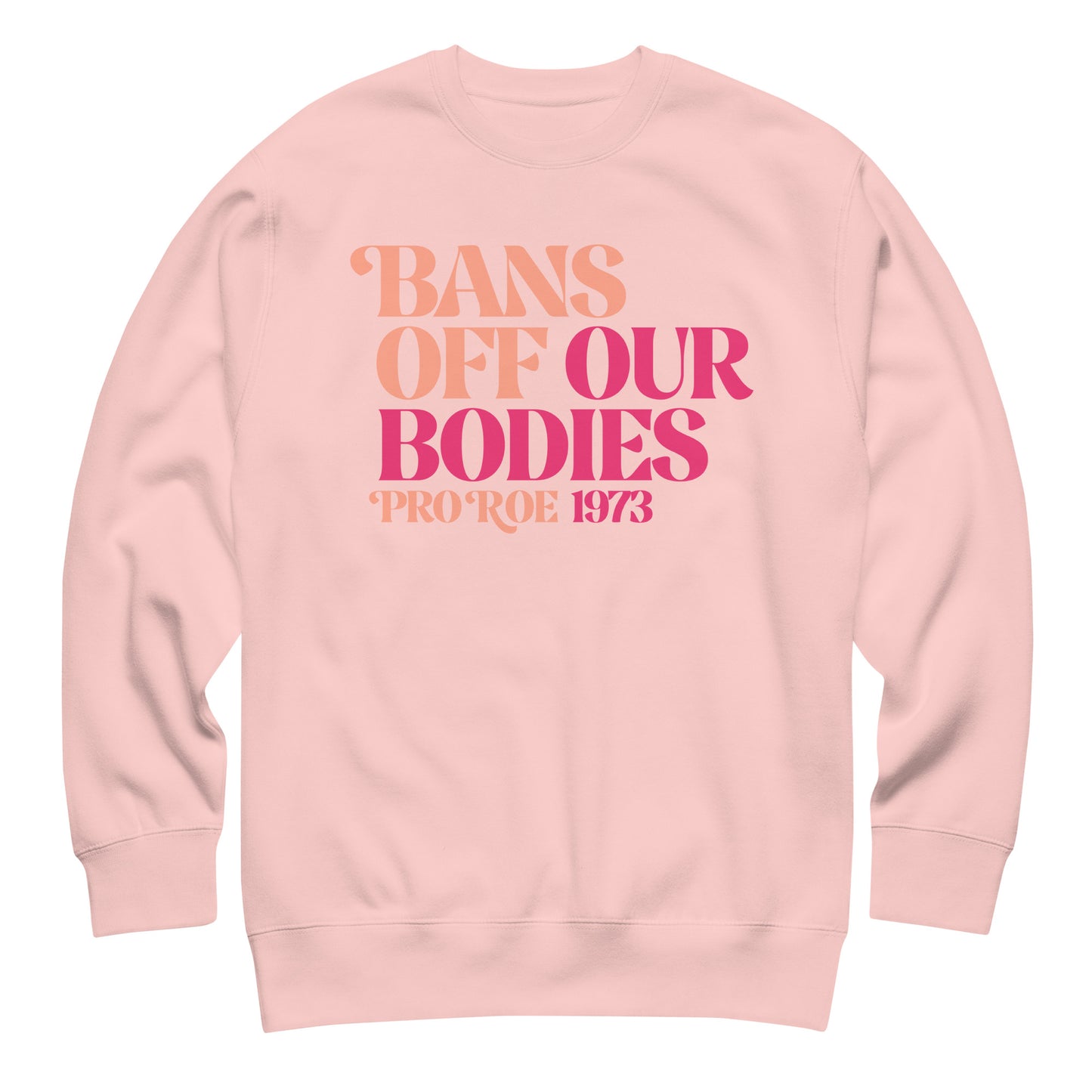 Light pink unisex premium sweatshirt featuring stacked vintage serif typography in pink gradient tones, centered design, printed message “BANS OFF OUR BODIES PRO ROE 1973,” reproductive rights apparel from Blue Wave USA.