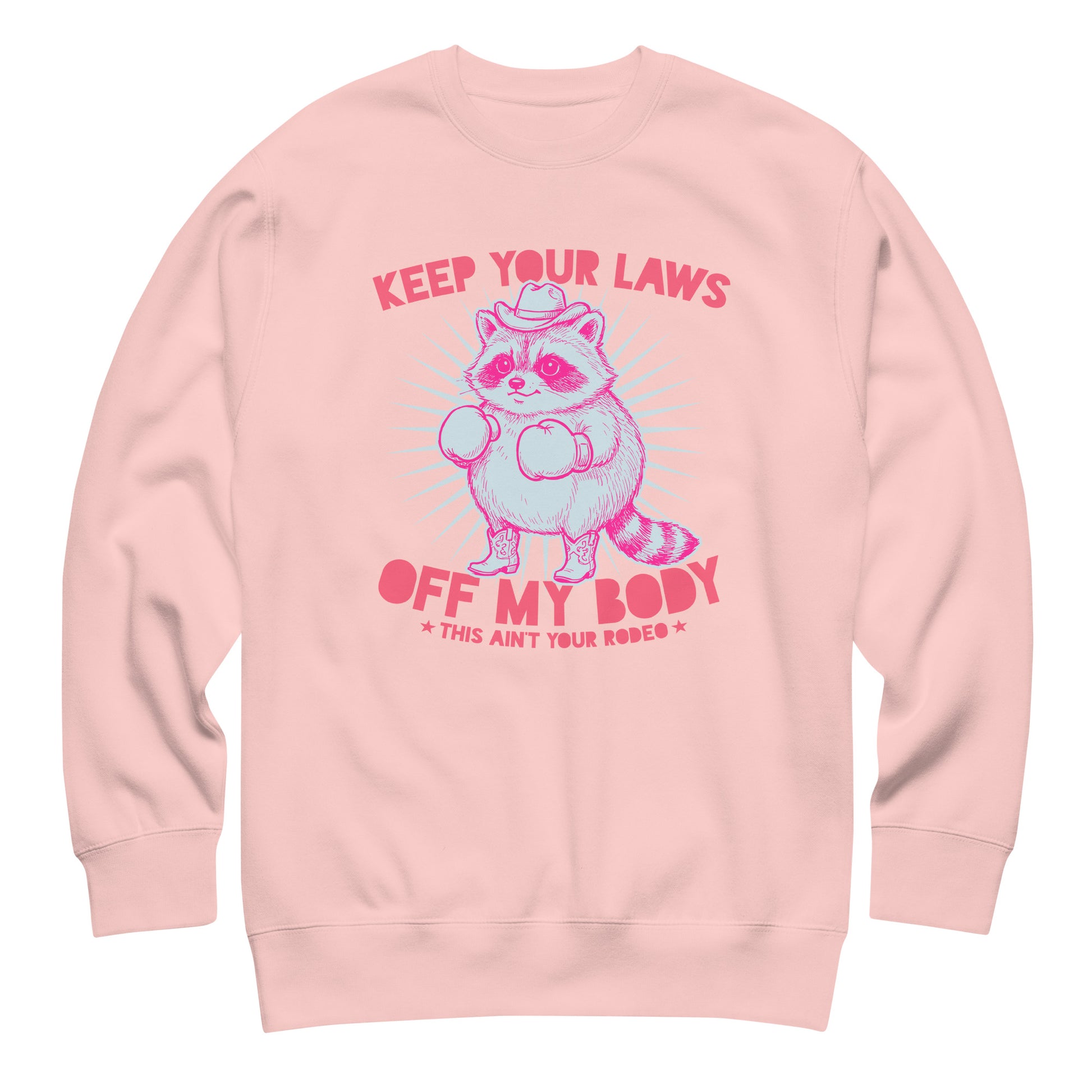 Pink unisex sweatshirt featuring cowboy raccoon illustration and reproductive rights slogan in soft feminist apparel design.