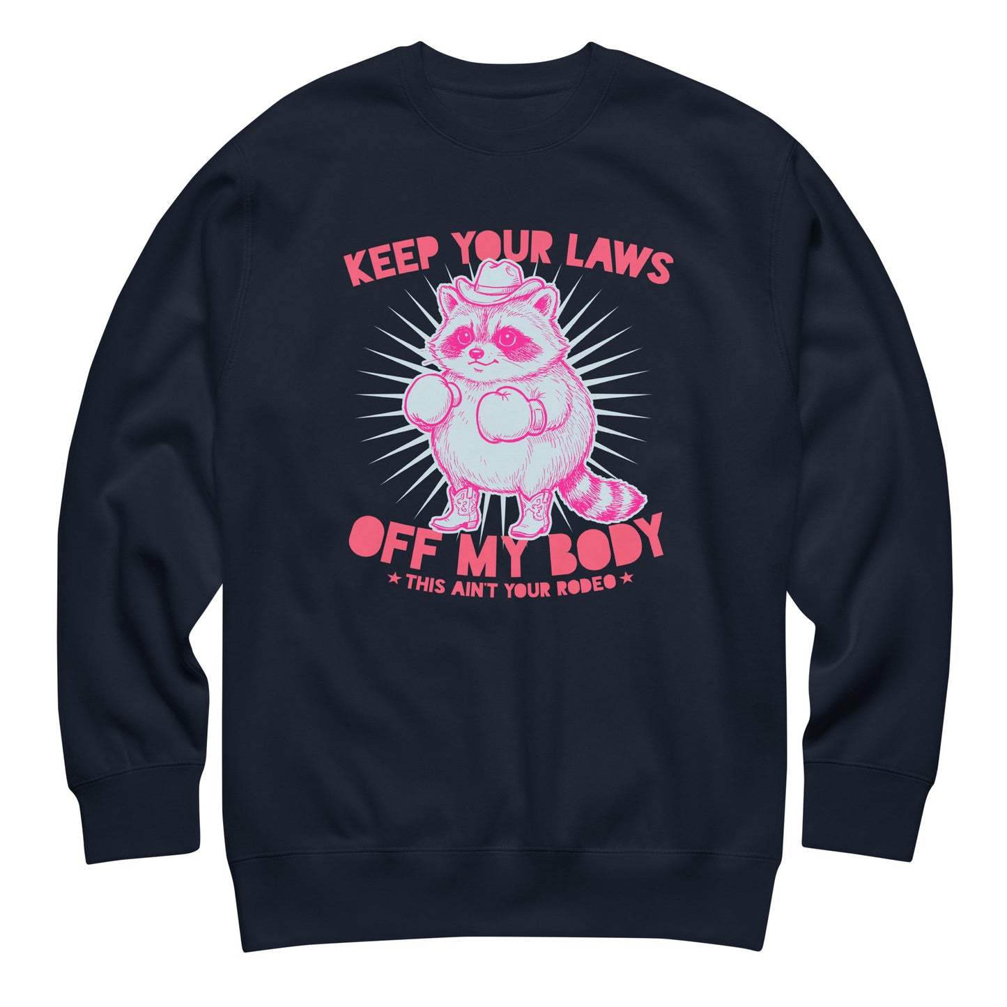 Navy unisex premium sweatshirt featuring raccoon cowboy graphic and “Keep Your Laws Off My Body” slogan in strong feminist apparel design.