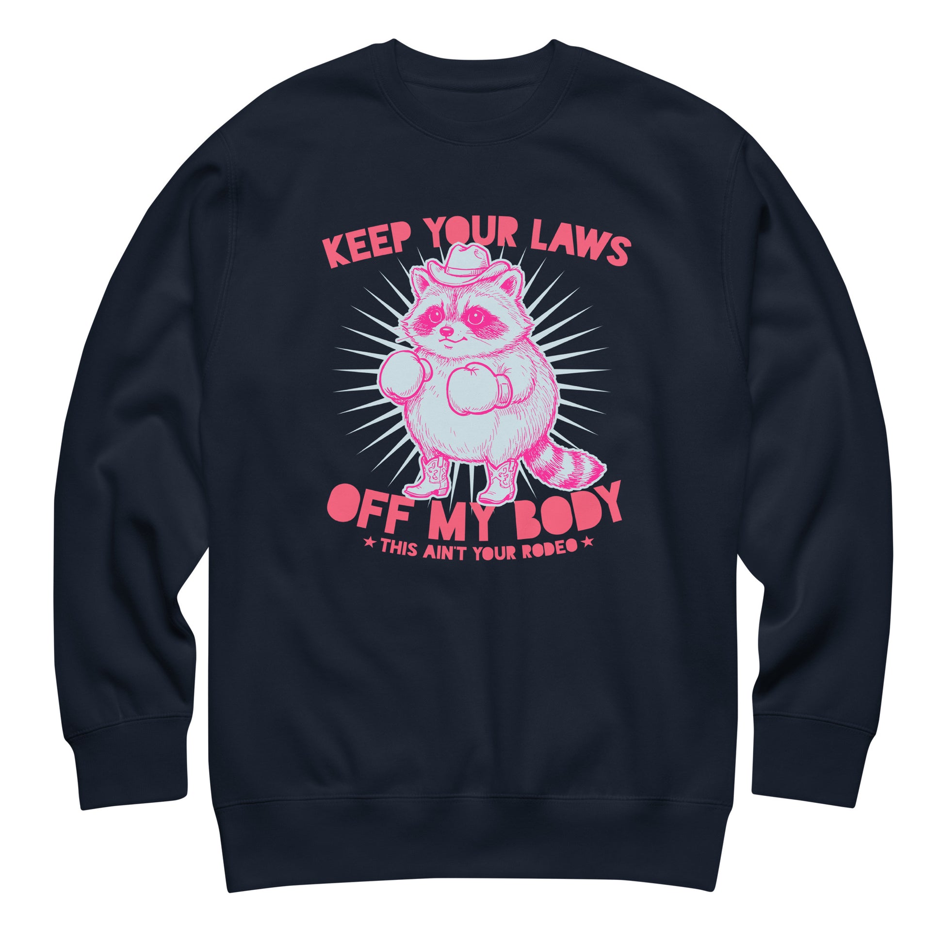 Navy unisex premium sweatshirt featuring raccoon cowboy graphic and “Keep Your Laws Off My Body” slogan in strong feminist apparel design.