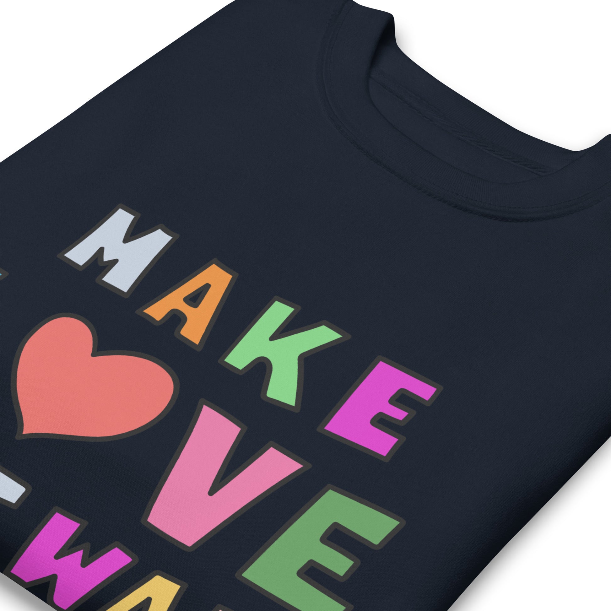 Close-up of colorful block lettering and heart icon on a navy unisex premium sweatshirt, highlighting crisp print details spelling “MAKE LOVE NOT WAR.”