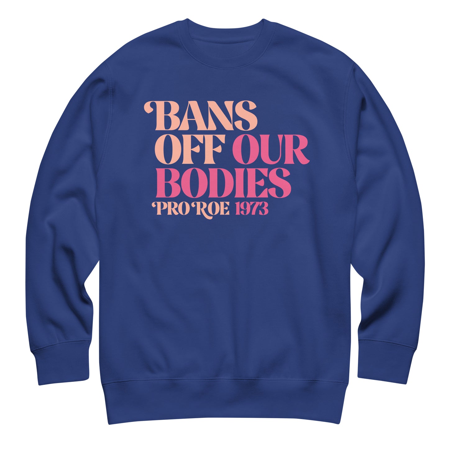 Royal blue unisex premium sweatshirt featuring bold feminist typography in pink gradient tones, stacked serif layout, printed message “BANS OFF OUR BODIES PRO ROE 1973.”