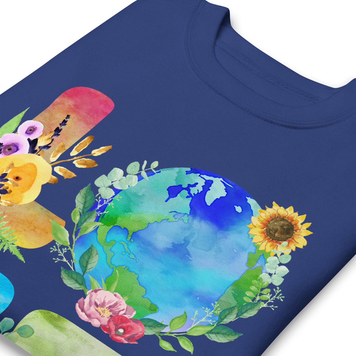 Close-up blue sweatshirt print showing globe, floral elements, and leaf details forming “LOVE” design in vibrant environmental artwork.