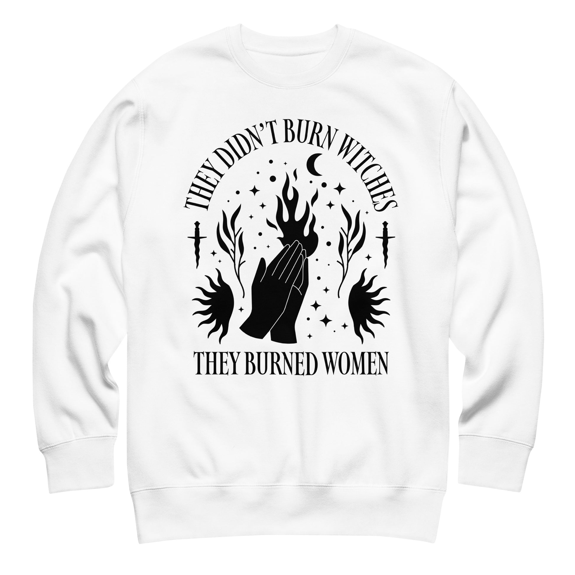 White unisex premium sweatshirt laid flat featuring bold occult illustration with raised hands, flames, and moons, centered composition, printed message “THEY DIDN’T BURN WITCHES THEY BURNED WOMEN.”