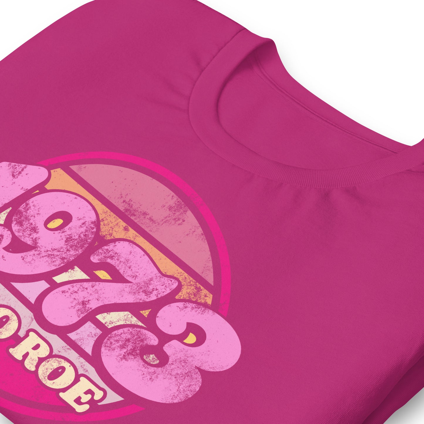 Close-up of the vintage print on a berry color unisex t-shirt, highlighting distressed textures, rounded typography, and the circular “1973 PRO ROE” emblem.