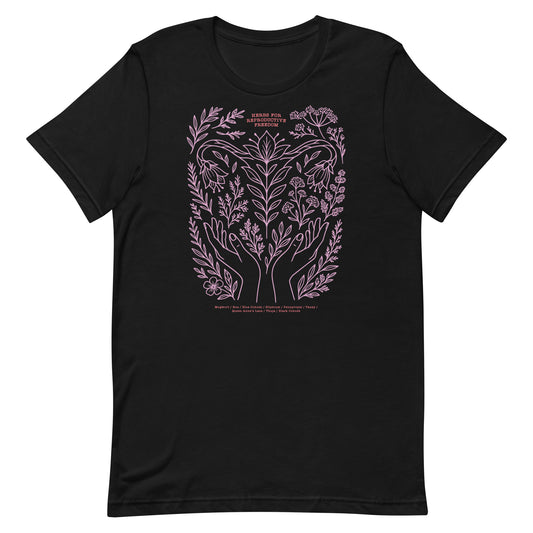 Black unisex t-shirt featuring pink botanical illustration with hands, herbs, and crescent moon, labeled with “Herbs for Reproductive Freedom.”