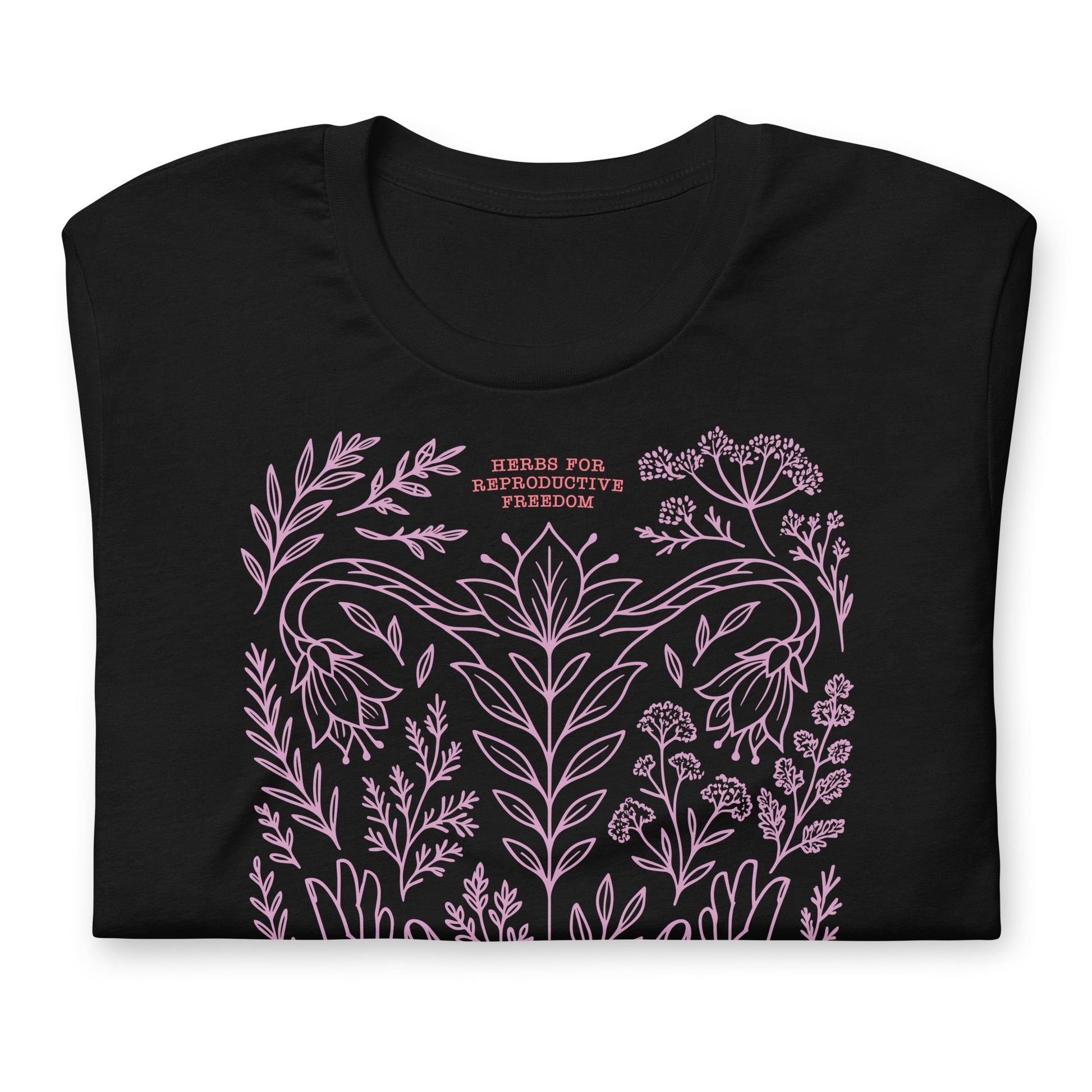 Close-up of the black herbal freedom t-shirt showing fine pink line art of herbs, flowers, and the crescent moon symbolizing care and resistance.