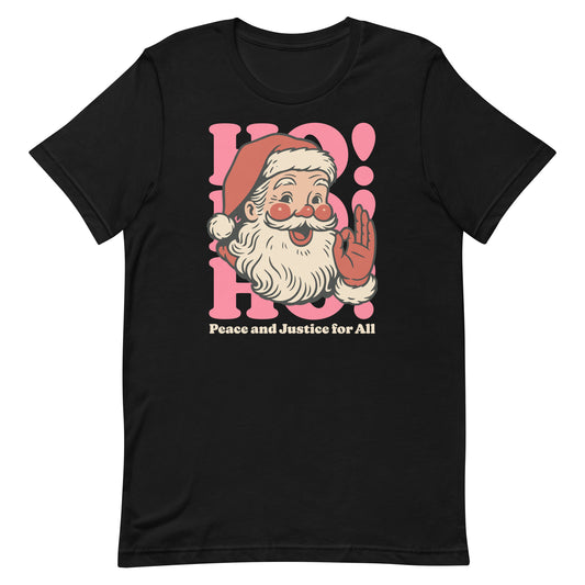 Black t-shirt featuring a retro Santa illustration with pink “HO! HO! HO!” lettering and the phrase “Peace and Justice for All,” displayed on a clean flat background.