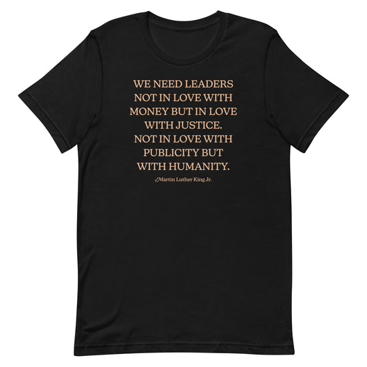 Black shirt with the printed quote: “WE NEED LEADERS NOT IN LOVE WITH MONEY BUT IN LOVE WITH JUSTICE… NOT IN LOVE WITH PUBLICITY BUT WITH HUMANITY.” A civil-rights design inspired by Martin Luther King Jr.