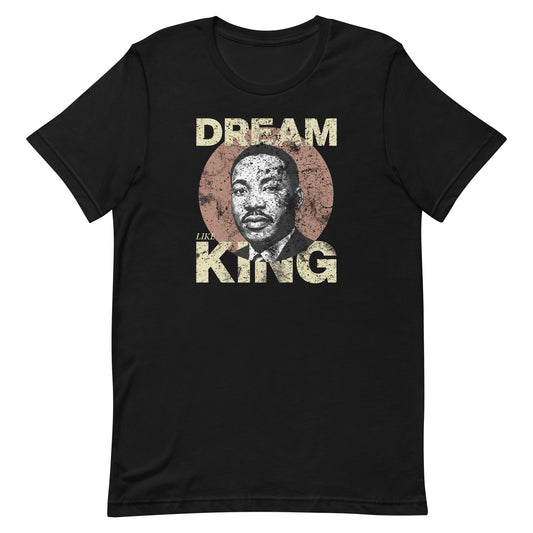 Black unisex t-shirt with the distressed “DREAM LIKE KING” text and MLK portrait inside a textured circle. Civil-rights design with vintage style. Blue Wave USA apparel.