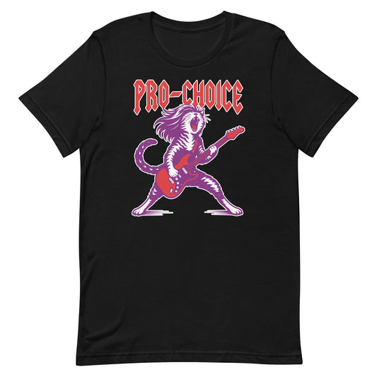 Black unisex t-shirt featuring a bold illustrated cat playing electric guitar in a heavy metal style, red lettering reading “PRO-CHOICE,” vibrant purple and pink graphic.