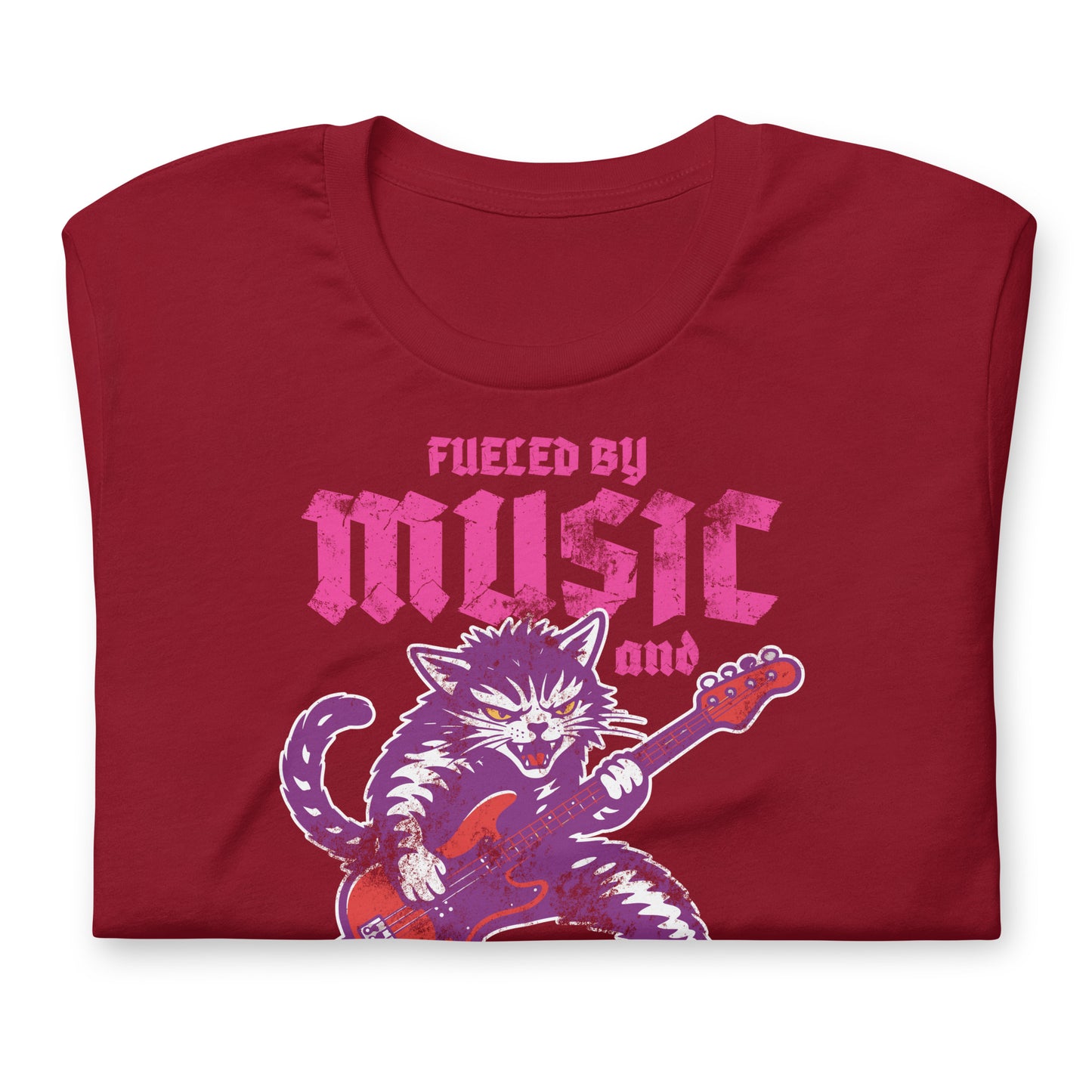 Folded cardinal red unisex t-shirt showing the illustrated punk rock cat graphic with electric guitar and bold text reading “FUELED BY MUSIC AND FEMINIST RAGE.”