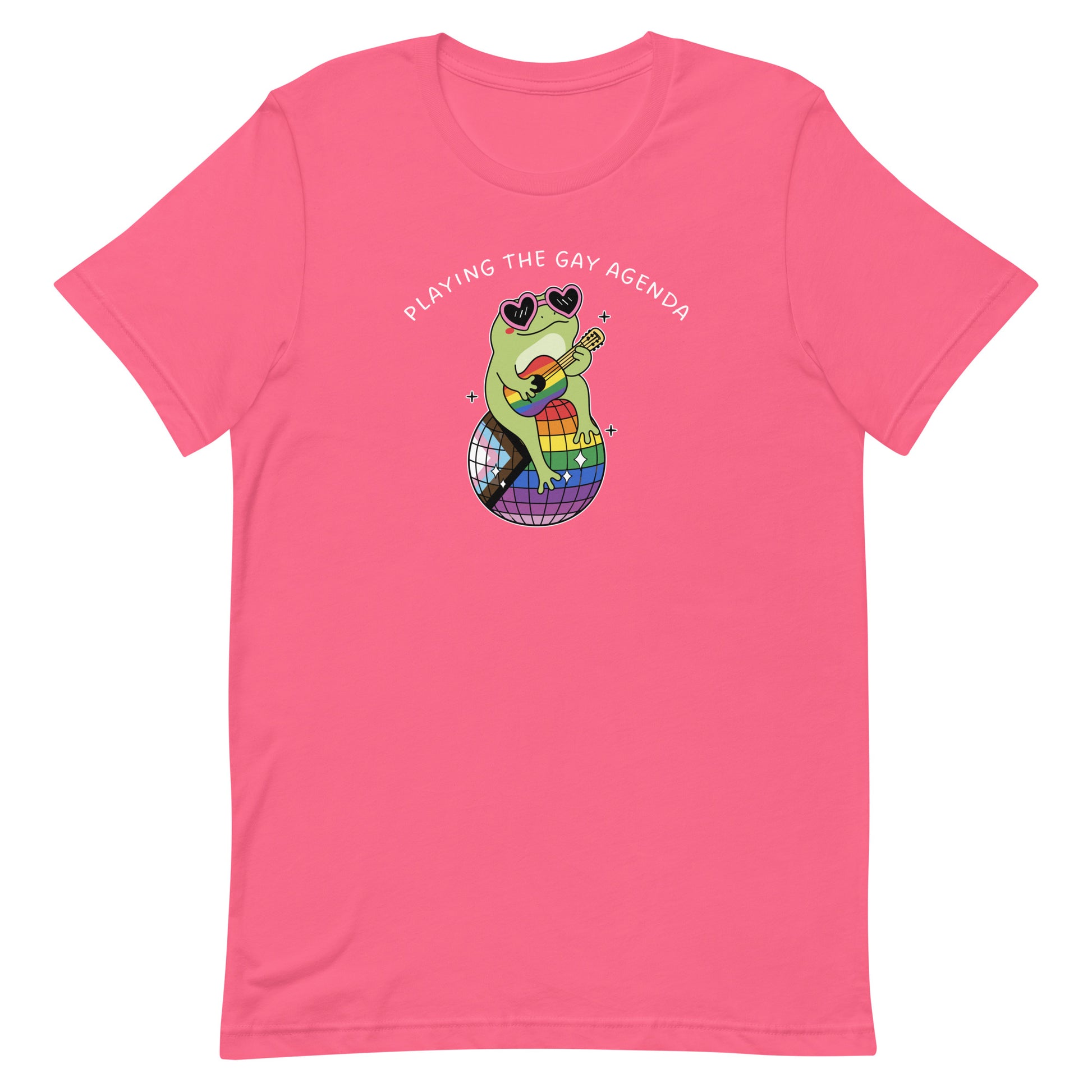 Pink unisex pride t-shirt featuring colorful frog artwork, rainbow disco ball, and “Playing the Gay Agenda” slogan celebrating queer joy and self-expression.