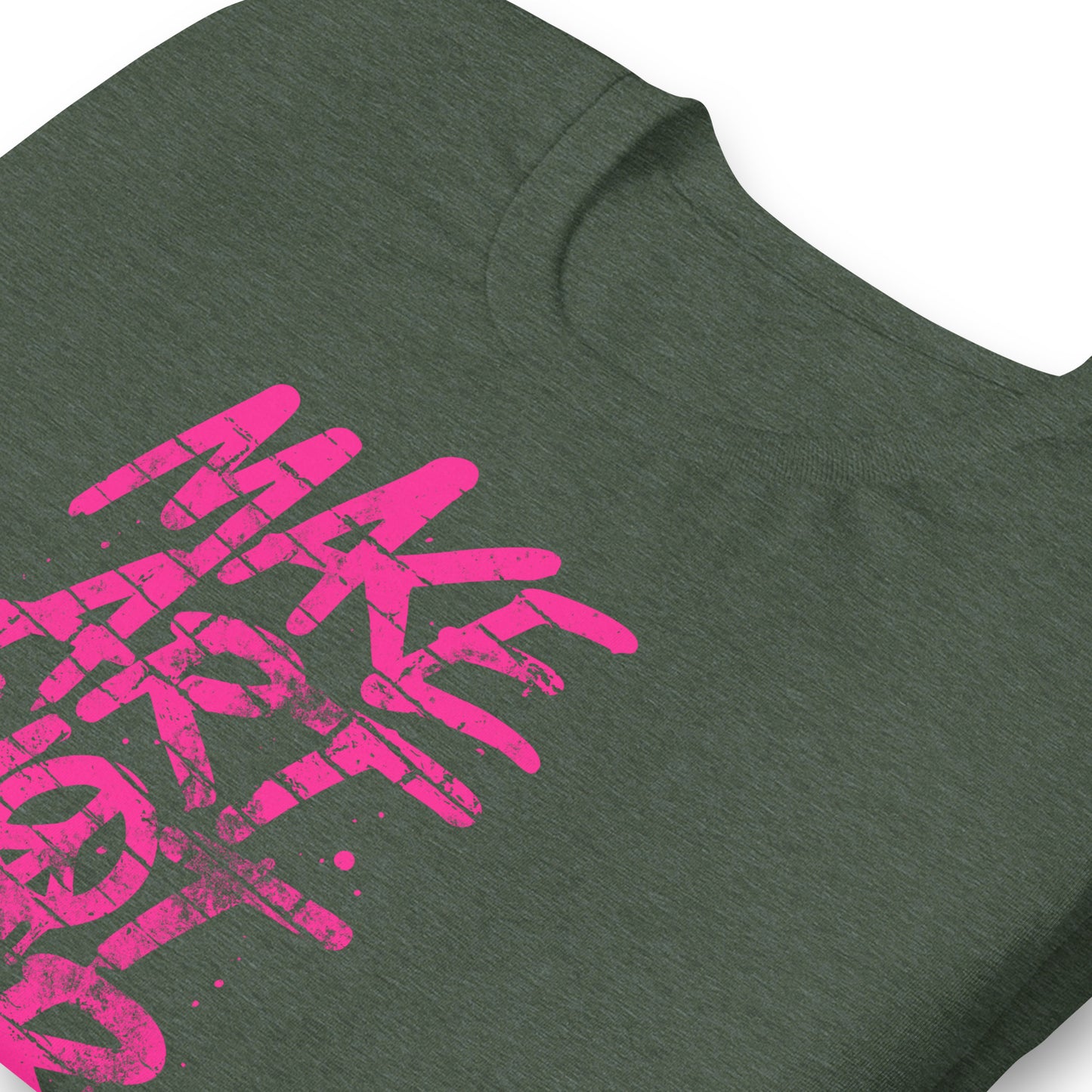 Close-up of heather forest green unisex t-shirt from Blue Wave USA showing textured fabric and vibrant pink graffiti lettering spelling “MAKE ART NOT WAR,” highlighting distressed brushstroke details of the print.