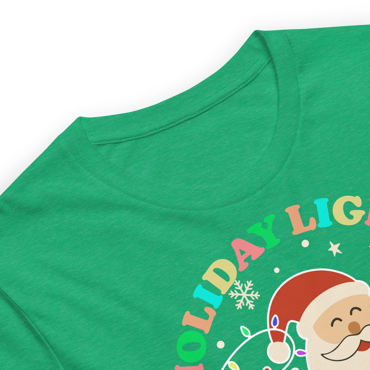 Close-up of a heather kelly round-neck t-shirt showing Santa, gifts, and holiday lights beneath the message “HOLIDAY LIGHTS ABOLISH ICE.”