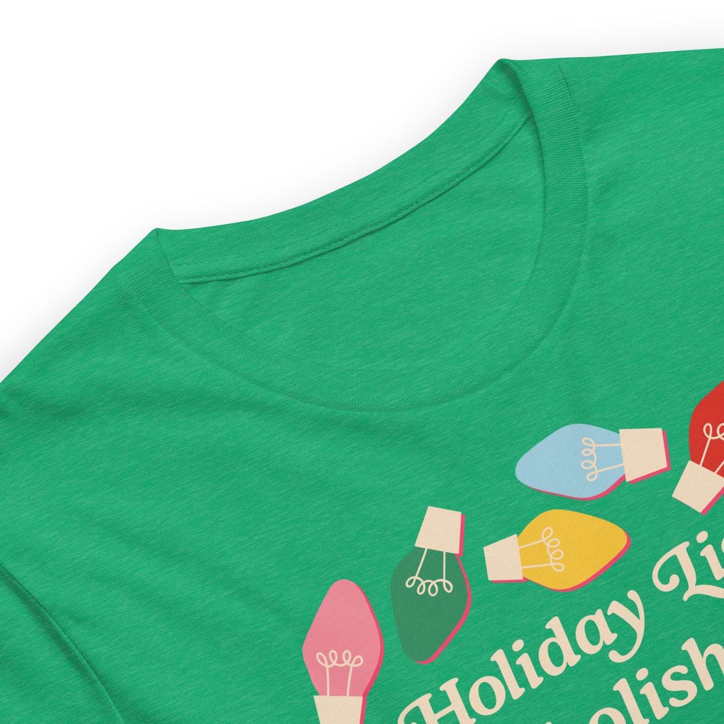 A close-up of a heather kelly unisex t-shirt showing vibrant holiday bulbs and part of the message “Holiday Lights Abolish ICE,” highlighting fabric texture and colorful holiday artwork.